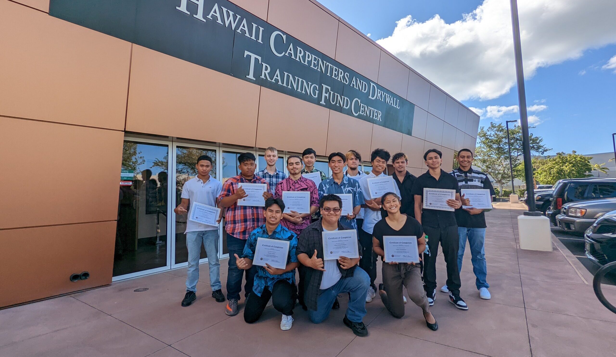 A group of summer interns pose outside the Training Center with their certificates in hand.