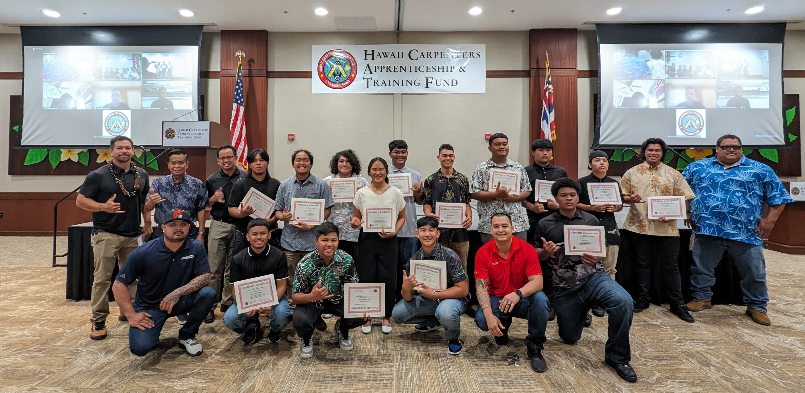A cohort of summer interns pose inside the HCATF ballroom with their certificates ad instructors after their recognition ceremony.